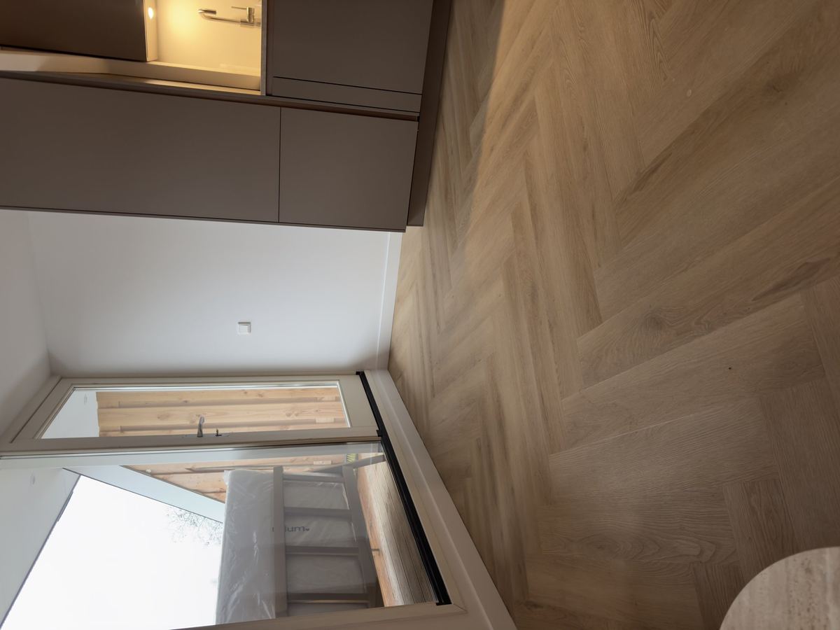 Brede PVC-planken rond het trapgat op de overloop, gelegd door VYDA